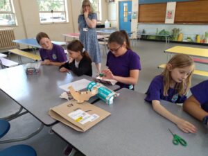 Pupil in fabrication team making model from cardboard