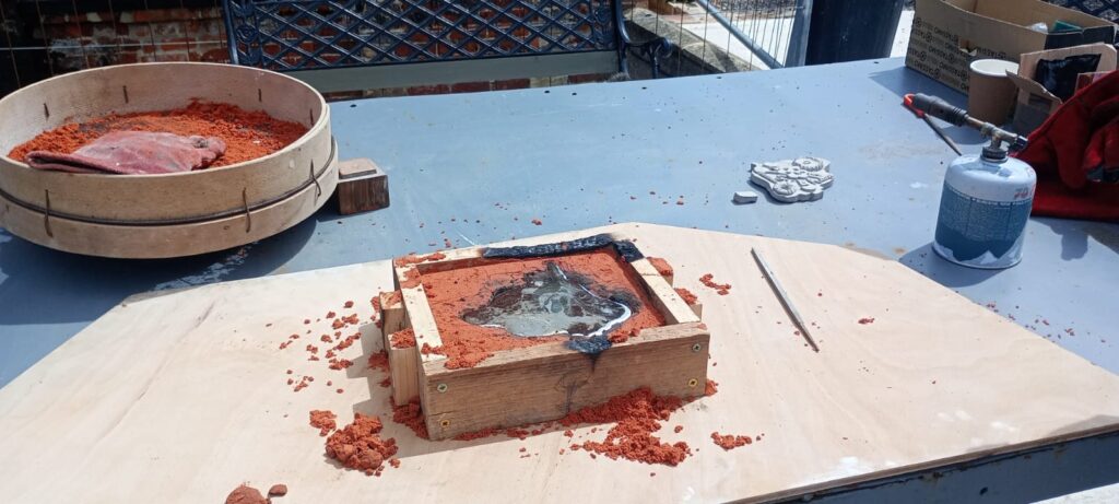 Molten pewter in the sand mould