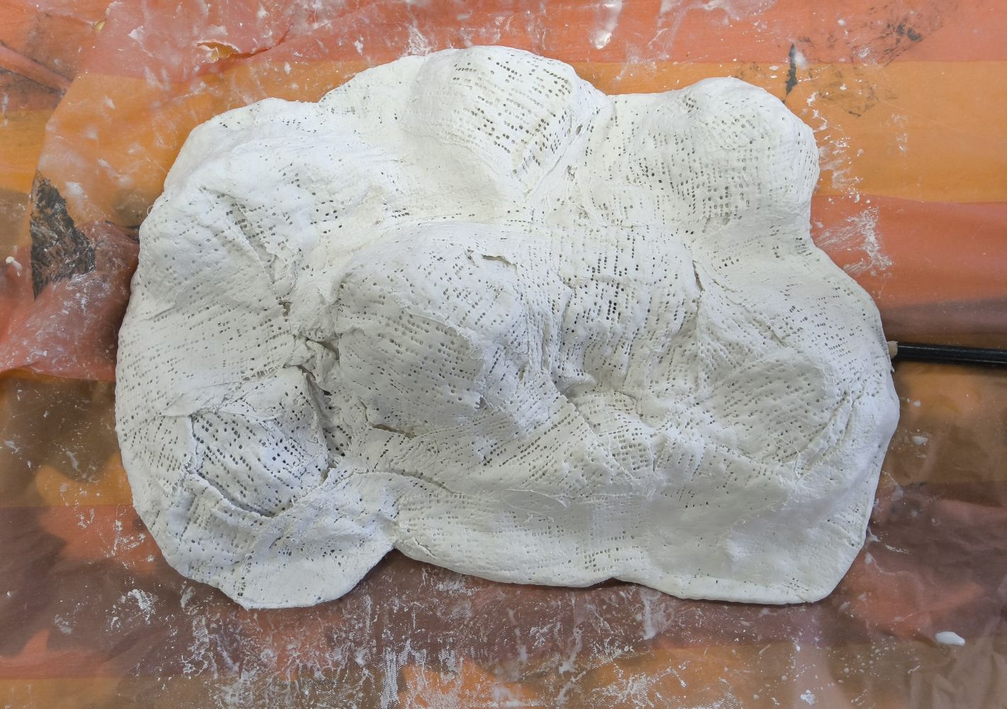 This lumpy white object is constructed of a cardboard base with scrumpled up newspaper taped to it and then covered in Modroc