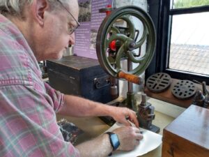 Participant taking rubbing from an industrial piece of equipment