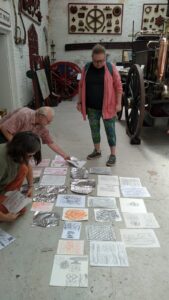 Rubbings and foil impressions laid out on the floor