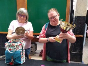 2 participants inspecting trophies