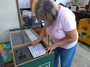 Participant taking a rubbing of an old piece of grating