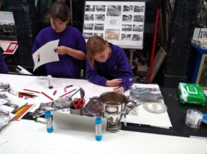 Pupils using their rubbings to create a collaged trophy