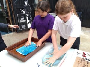 2 pupils rinsing their pictures