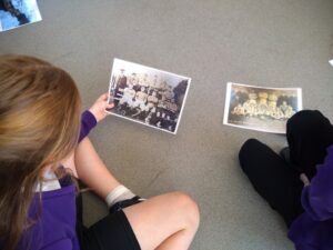 2 pupils looking at photos of football teams