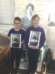 2 pupils holding old images of female footballers