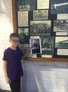 Pupil matching his copy of the photograph to a Museum display of women workers at Garretts