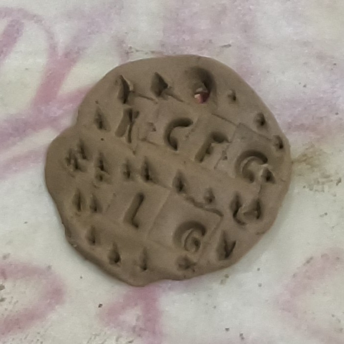 A clay disc impressed with letters