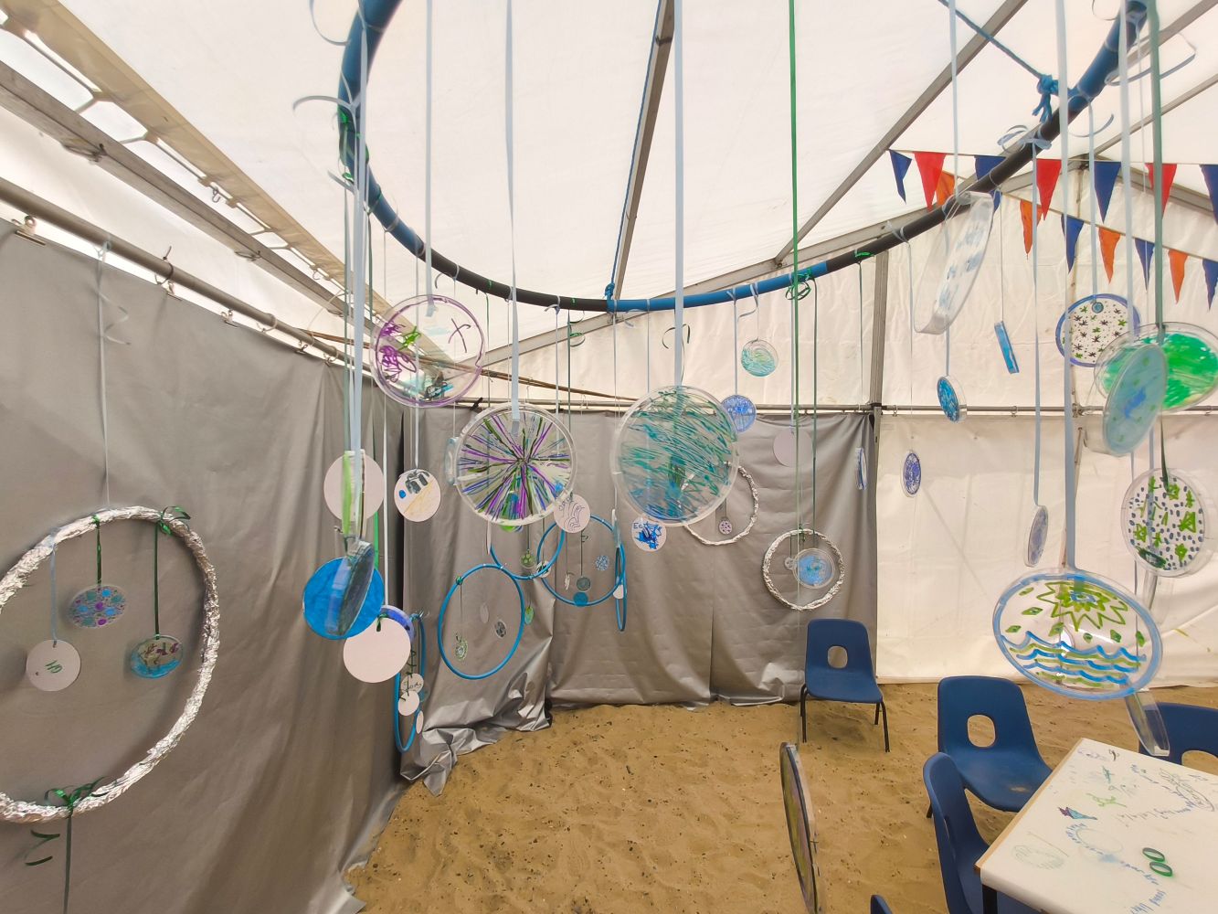 A festoon of coloured discs and hoops against a silver backdrop