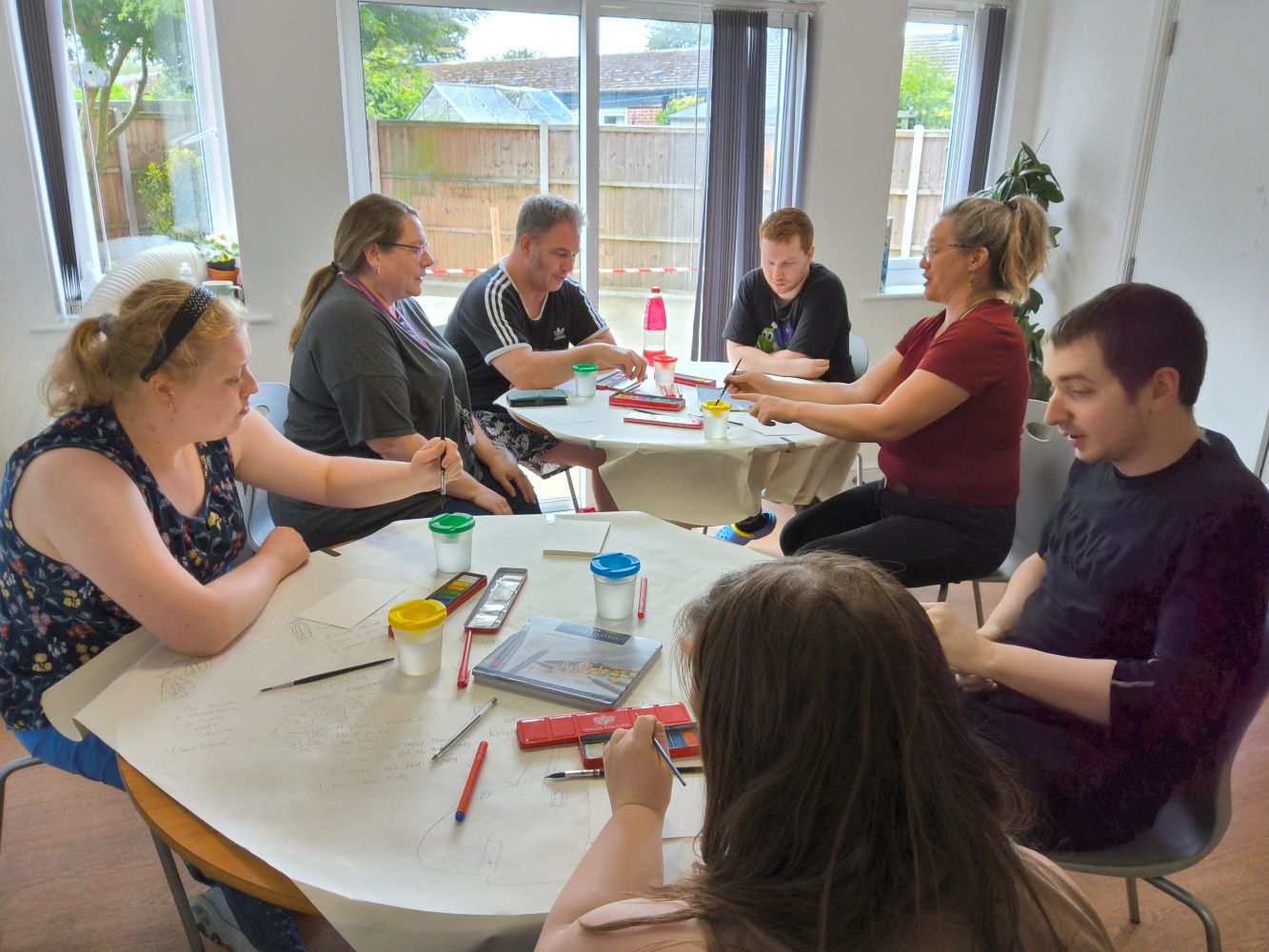 A group of people seated around a two tables