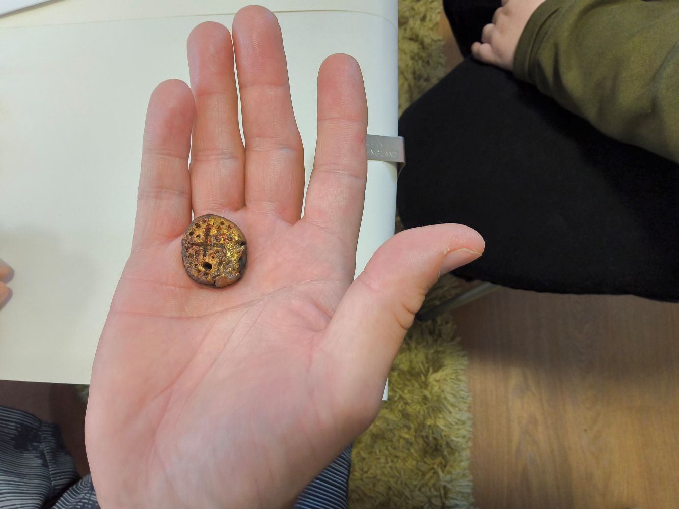 An open hand, in the palm of which is a copper coin