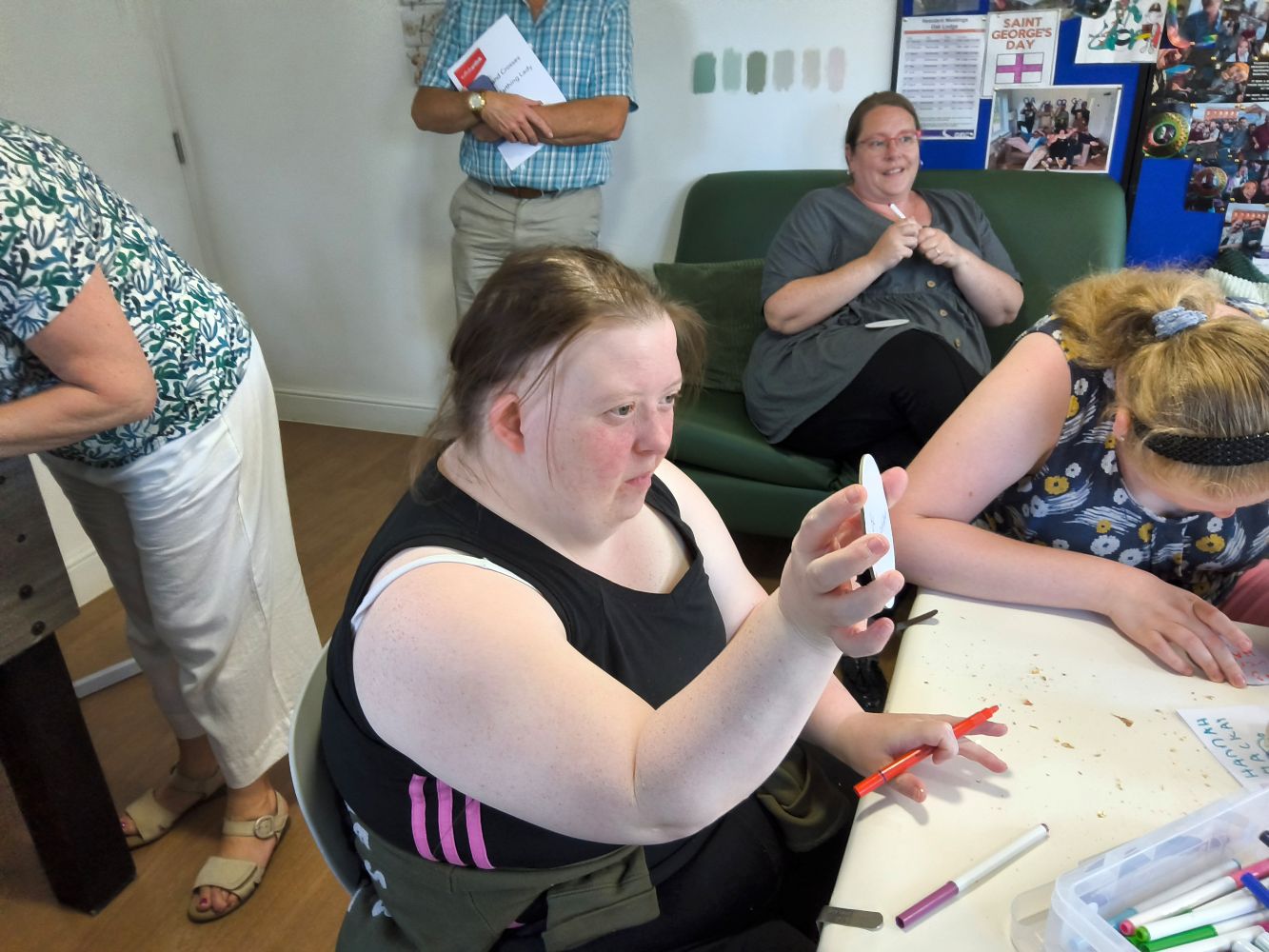 A group of individuals writing, drawing and showing comments written on white card discs