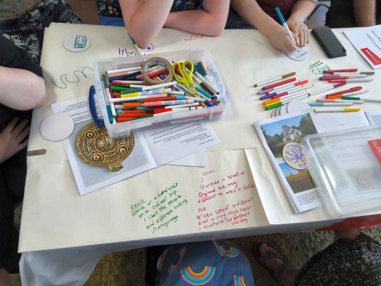 A table covered with art materials and written text Lewis France in a Hovercraft on a school trip I liked the people and different talking language