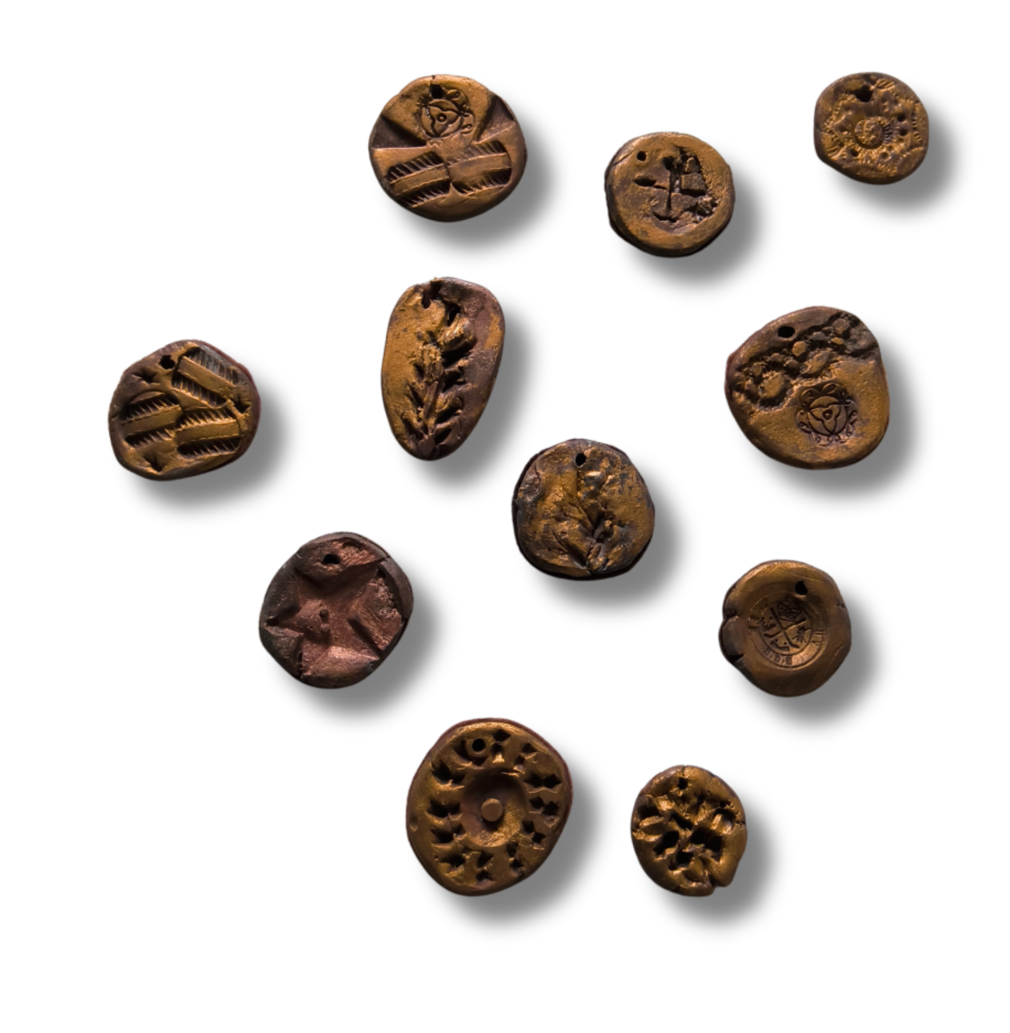 11 bronze coins, createde out of metal-clay and imprinted with different patterns and designs