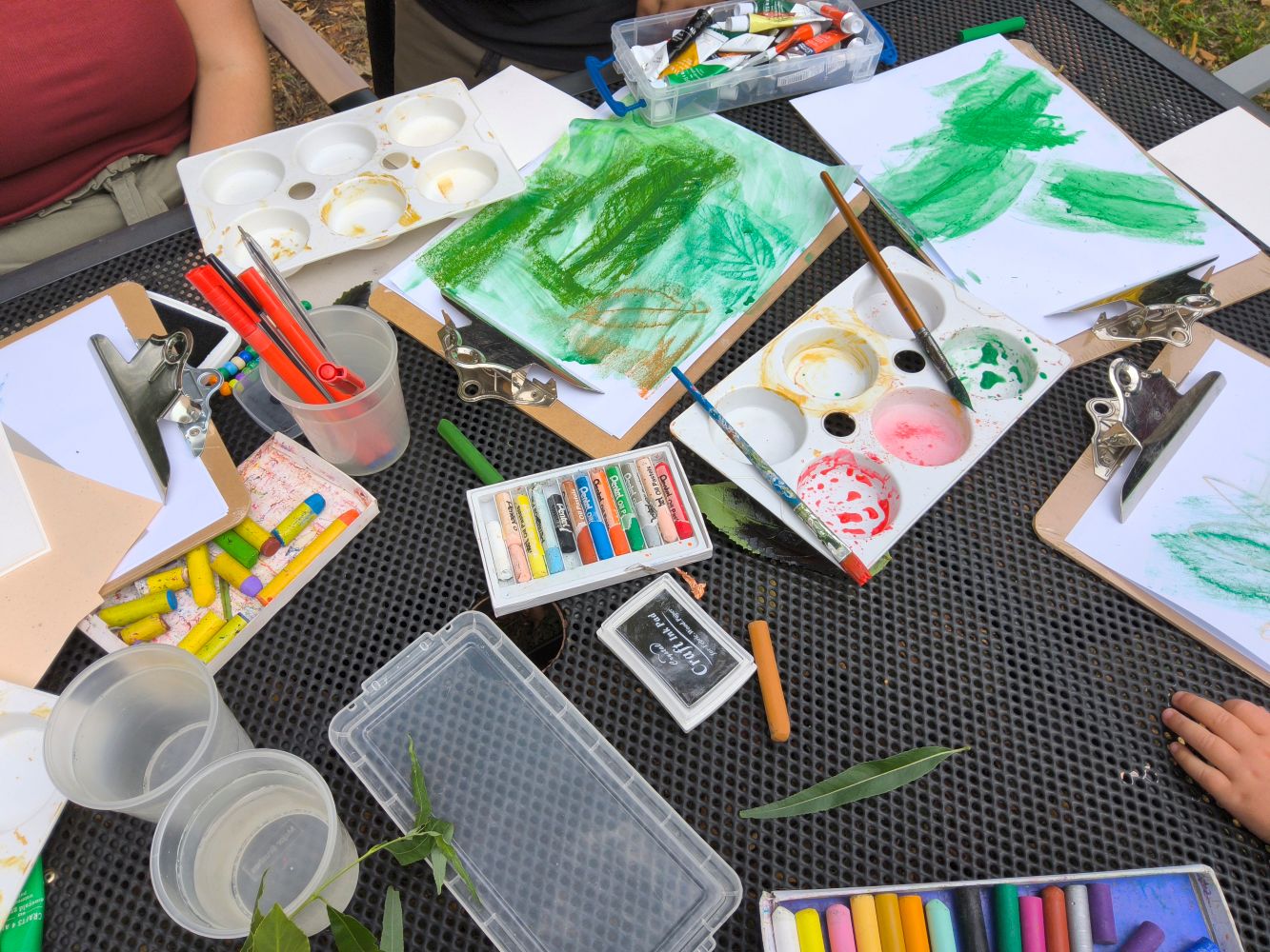 A collection of art materials and drawings and rubbings of leaves