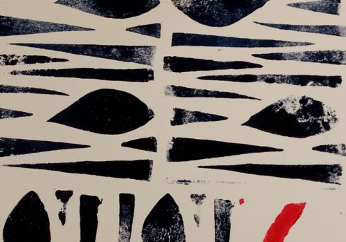 Block printed design with repeated pattern of interlaced black triangles around a black almond shape. There is a red zig-zag in the bottom right hand corner of the image.